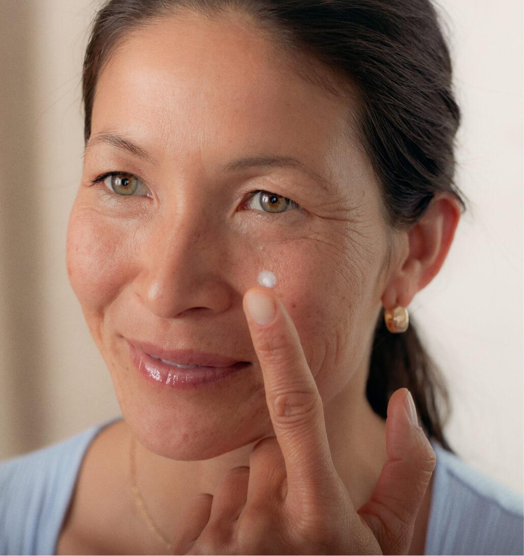Women applies one dab of Agency Dark Spot Formula to face with one finger